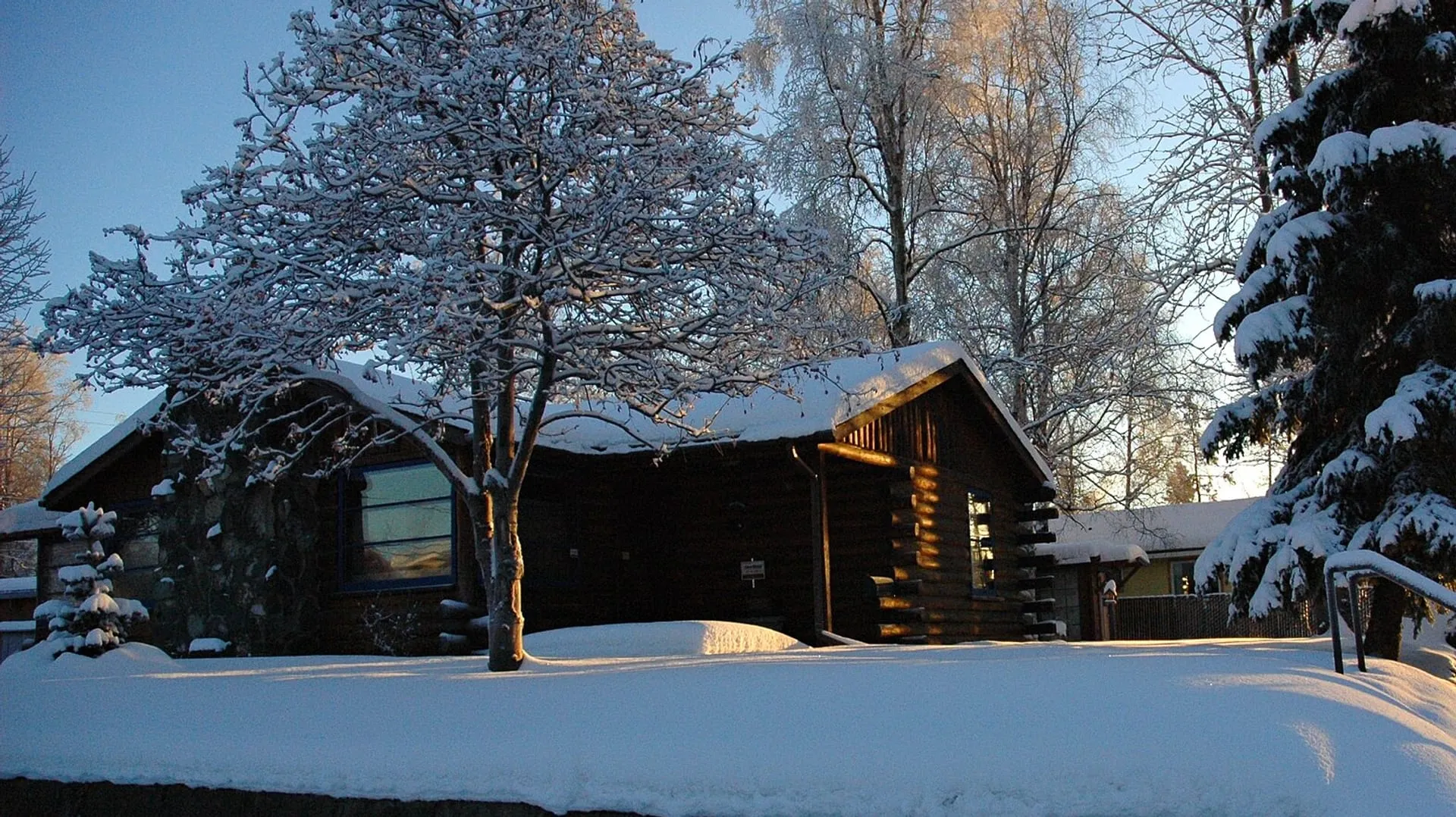 Log chalet in deep snow at first light, Eastern Townships