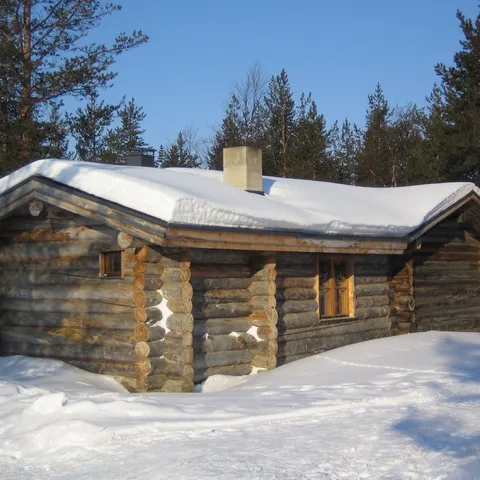 Chalet en bois rond sous la neige